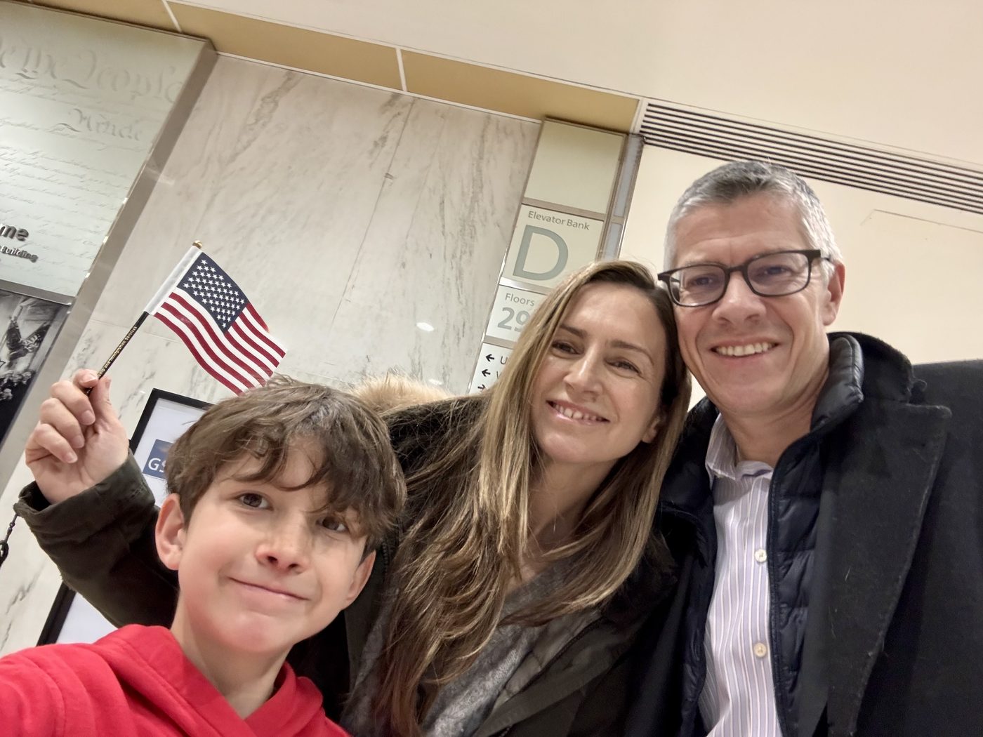 Our family on our mother's naturalization day, holding an American flag